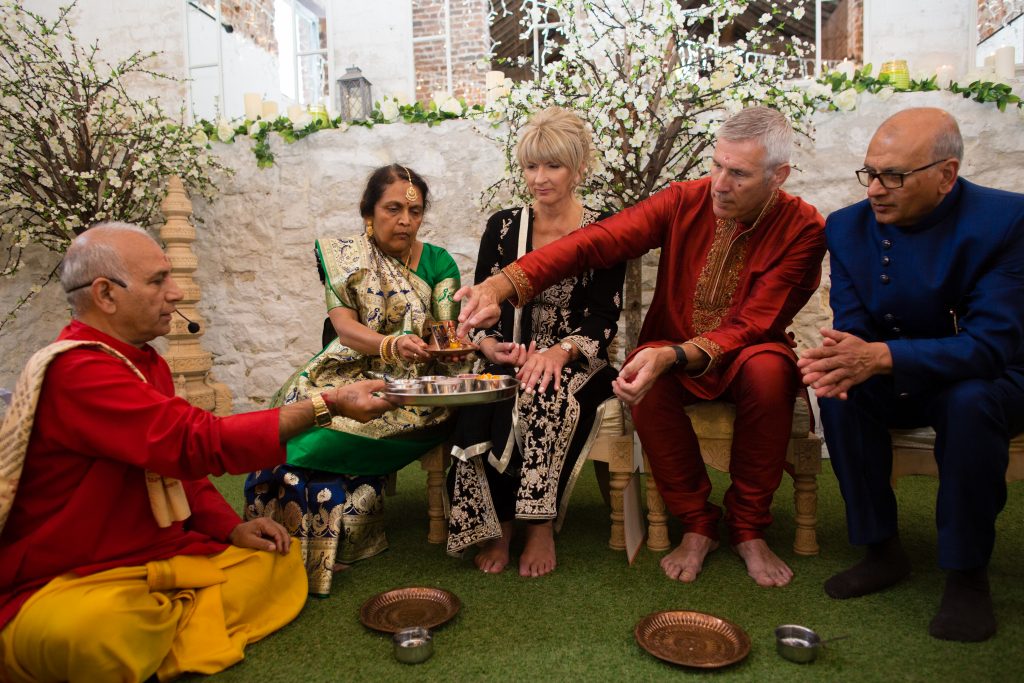 family taking part in hindu wedding ceremony